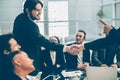 smiling business people shaking hands over an office Desk Royalty Free Stock Photo