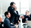 smiling business people shaking hands over an office Desk Royalty Free Stock Photo