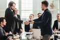 Smiling business people shaking hands over an office Desk Royalty Free Stock Photo