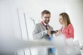 Smiling business people using smart phone in convention center Royalty Free Stock Photo