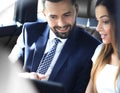 Smiling business people working in backseat of car Royalty Free Stock Photo