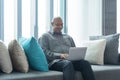 Smiling business senior old elderly Black American man, African person working from home on table with computer notebook laptop in Royalty Free Stock Photo