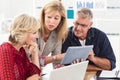 Smiling business team discussing over a tablet Royalty Free Stock Photo