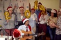 Smiling business team have fun and dancing in Santa hat at Xmas party Royalty Free Stock Photo