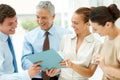 Smiling business team working together. Happy young businesswoman discussing some work with her business colleagues. Royalty Free Stock Photo