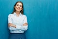 Smiling business woman with crossed arms portrait on blue wall. Royalty Free Stock Photo