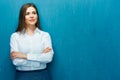 Smiling business woman with crossed arms portrait on blue wall. Royalty Free Stock Photo