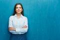 Smiling business woman with crossed arms portrait on blue wall. Royalty Free Stock Photo