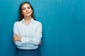 Smiling business woman with crossed arms portrait on blue wall. Royalty Free Stock Photo