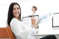 Smiling business woman with financial documents sitting at work desk. Royalty Free Stock Photo