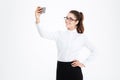 Smiling business woman in glasses making selfie using cell phone Royalty Free Stock Photo