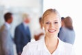 Smiling business woman with her team. Portrait of young business woman smiling with team in background. Royalty Free Stock Photo