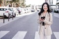 Smiling business woman listening to music on headphones and mobile phone crossing street in city Royalty Free Stock Photo
