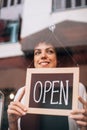 Smiling business woman putting an open sign on the glass door Royalty Free Stock Photo