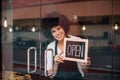 Smiling business woman putting an open sign on the glass door Royalty Free Stock Photo