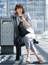 Smiling business woman reading text message on mobile phone Royalty Free Stock Photo