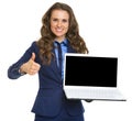 Smiling business woman showing laptop blank screen and thumbs up Royalty Free Stock Photo