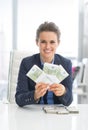 Smiling business woman showing money packs