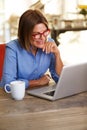 Smiling business woman sitting at desk working on laptop Royalty Free Stock Photo