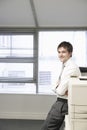 Smiling Businessman Against Photocopier In Office Royalty Free Stock Photo