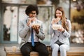 Businessman and businesswoman with sandwiches sitting in front of the office building - lunch break Royalty Free Stock Photo