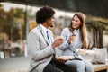 Businessman and businesswoman with sandwiches sitting in front of the office building - lunch break Royalty Free Stock Photo