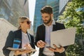 Smiling businessman and businesswomen working outdoor on laptop with new startup project Royalty Free Stock Photo