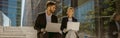 Man and woman in classic suit discussing business details and using laptop while sitting outdoors Royalty Free Stock Photo