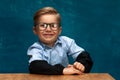 Smiling businessman child sitting at the table Royalty Free Stock Photo
