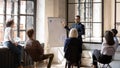 Smiling businessman coach giving flip chart presentation at briefing Royalty Free Stock Photo