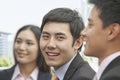 Smiling businessman with colleagues looking at camera Royalty Free Stock Photo