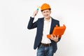Smiling businessman in dark suit, protective hardhat holding case with instruments or toolbox and beating himself on Royalty Free Stock Photo