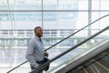 Smiling businessman going up an escalator Royalty Free Stock Photo