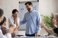 Smiling businessman greeting female employee with job success