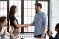 Smiling businessman handshake female employee greeting with success