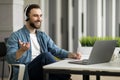 Smiling Businessman In Headphones Making Video Call And Taking Notes At Workplace Royalty Free Stock Photo