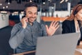 Smiling businessman in headphones talking online with client sitting in office Royalty Free Stock Photo