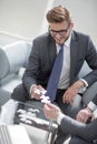 Smiling businessman helping the partner to complete the puzzle