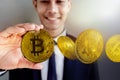 Smiling Businessman holding Golden Bitcoin Money. Happy to Earn