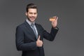 smiling businessman holding golden credit card and showing thumb up,