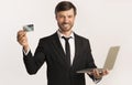 Smiling Businessman Holding Laptop And Credit Card, White Background Royalty Free Stock Photo