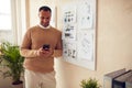 Smiling Businessman Holding Smartphone. Multiracial Guy Typing Message At Mobile Royalty Free Stock Photo