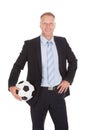 Smiling businessman holding soccer ball Royalty Free Stock Photo