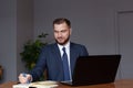 Smiling businessman with laptop computer, notebook and documents at office Royalty Free Stock Photo