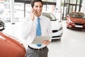 Smiling businessman on the phone holding clipboard Royalty Free Stock Photo