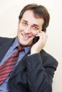 Smiling businessman with phone inclining left