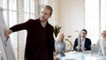 Smiling businessman present project on whiteboard at meeting Royalty Free Stock Photo