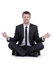 Smiling businessman relaxes sitting in the Lotus position