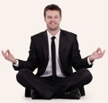 Smiling businessman relaxes sitting in the Lotus position