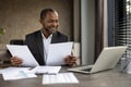 Smiling businessman reviewing documents at his desk Royalty Free Stock Photo